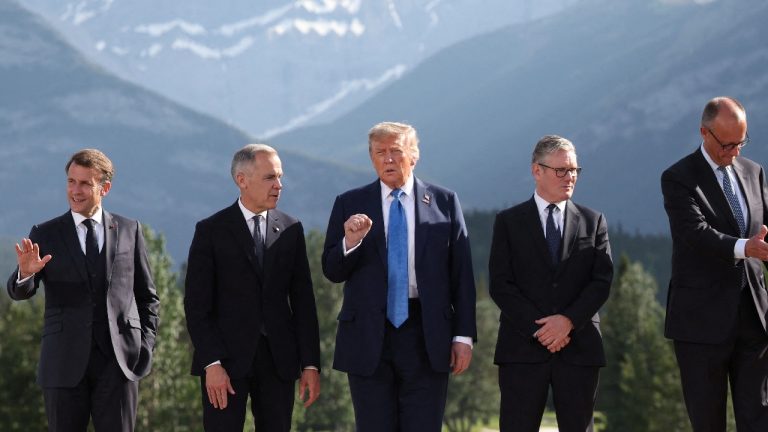 A line of European leaders and Donald Trump walking together outdoors, with Trump in the center