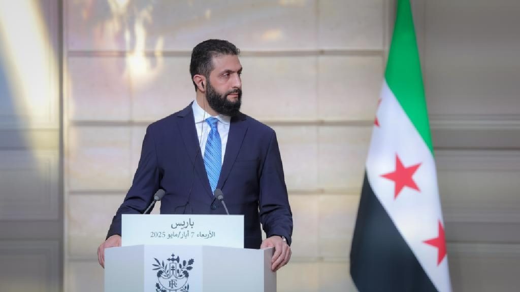 A wide view of a city in Syria, showing areas of destruction contrasted with signs of tentative rebuilding after the fall of Bashar al-Assad