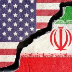American and Iranian flags painted on a cracked concrete wall representing fractured diplomatic relations.