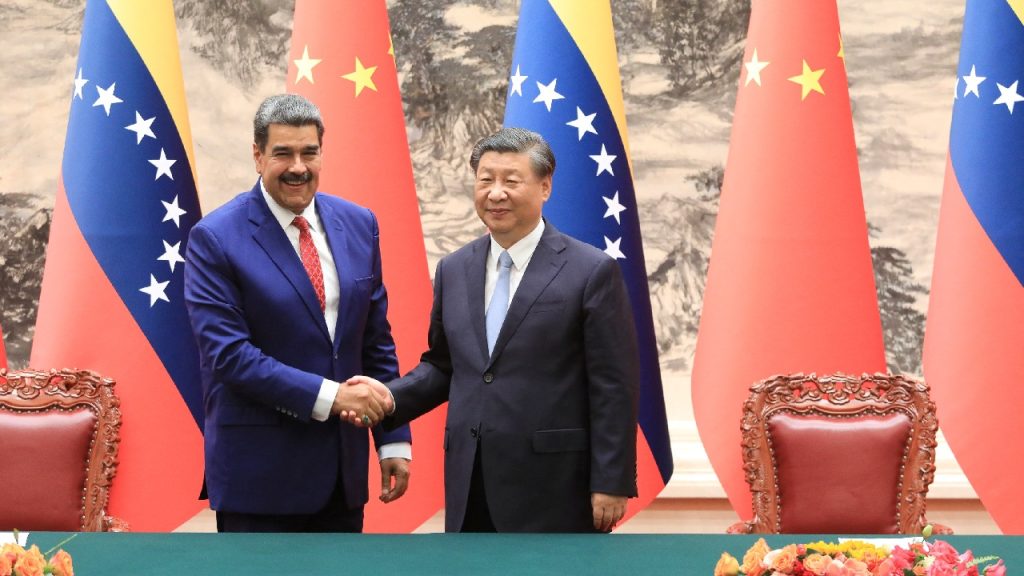 Chinese President Xi Jinping and Venezuelan President Nicolás Maduro shaking hands in front of several Chinese and Venezuelan flags