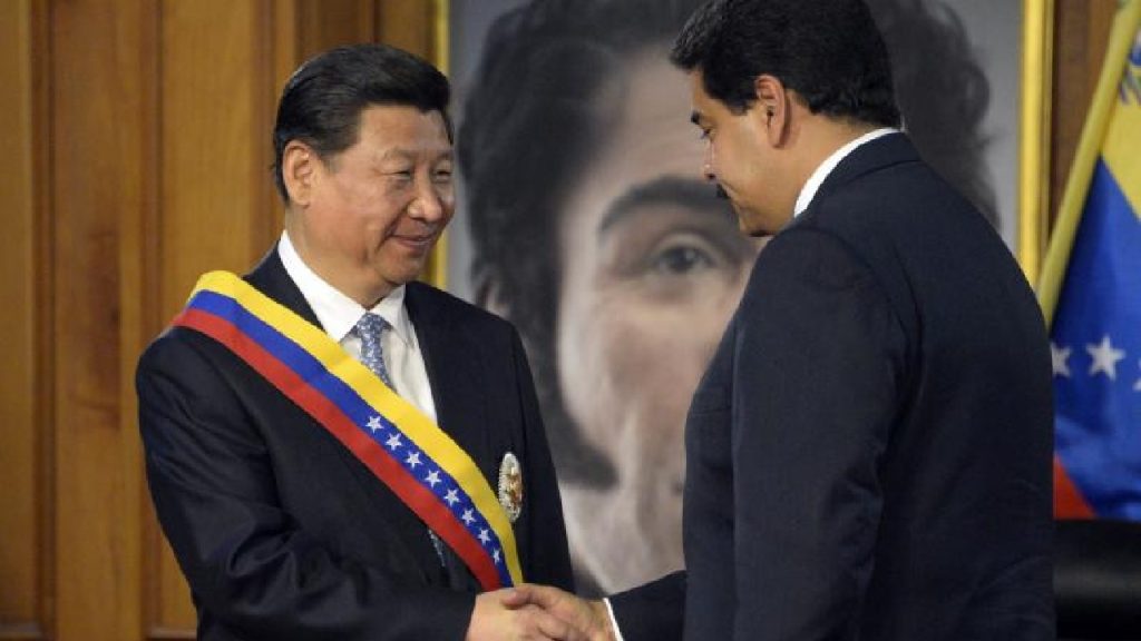 Chinese President Xi Jinping and Venezuelan President Nicolás Maduro smiling and shaking hands during a formal meeting.