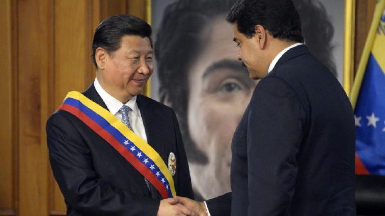 Chinese President Xi Jinping and Venezuelan President Nicolás Maduro smiling and shaking hands during a formal meeting.