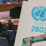 A meeting of the UN Security Council, with an overlay graphic showing the UN logo, "Resolution 2803," and a partitioned map of Gaza