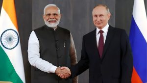 Indian Prime Minister Narendra Modi and Russian President Vladimir Putin shaking hands in front of the flags of India and Russia