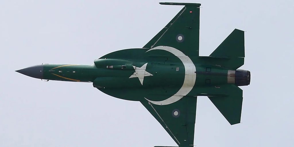 JF-17 Thunder fighter jet with the Pakistani flag painted on its fuselage flying against a clear sky.