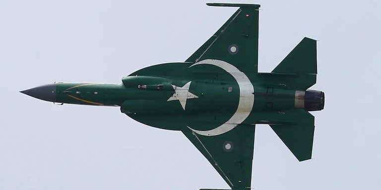 JF-17 Thunder fighter jet with the Pakistani flag painted on its fuselage flying against a clear sky.