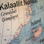 A close-up, shallow depth-of-field photograph of a geographical globe focusing on Greenland (Kalaallit Nunaat) and Iceland.