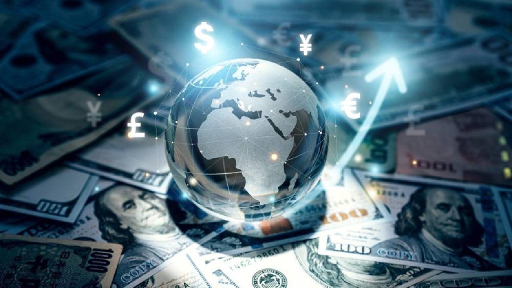 A glass globe of the Earth sits atop a pile of various international banknotes, surrounded by glowing digital currency symbols and a rising arrow.