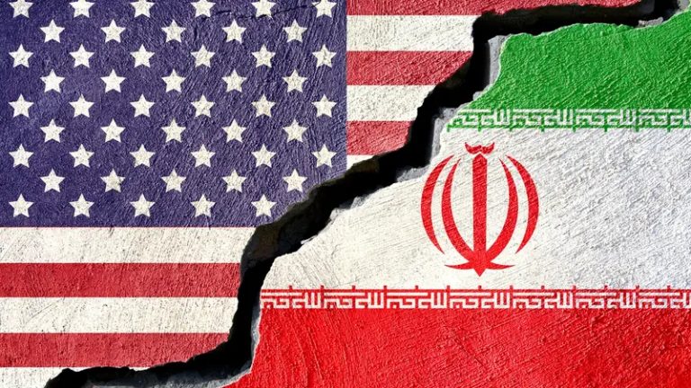 American and Iranian flags painted on a cracked concrete wall representing fractured diplomatic relations.