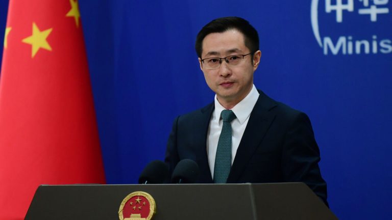 Chinese Foreign Ministry spokesperson Lin Jian speaking at a press conference podium with the Chinese flag in the background.