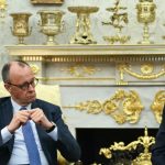 German politician Friedrich Merz and Donald Trump sitting in an ornate room during a meeting.