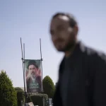 High-angle shot of Donald Trump looking down thoughtfully while adjusting his cufflinks.