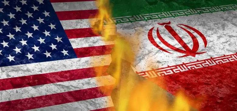 A conceptual image showing the USA and Iran flags separated by a deep, fiery crack in a stone surface.