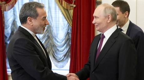Vladimir Putin shaking hands with an Iranian official in a formal setting.