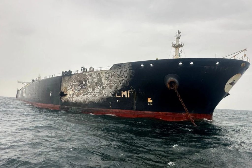 A large oil tanker at sea showing visible damage and burn marks on its hull.