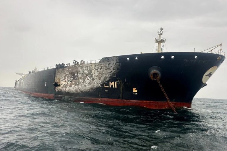 A large oil tanker at sea showing visible damage and burn marks on its hull.