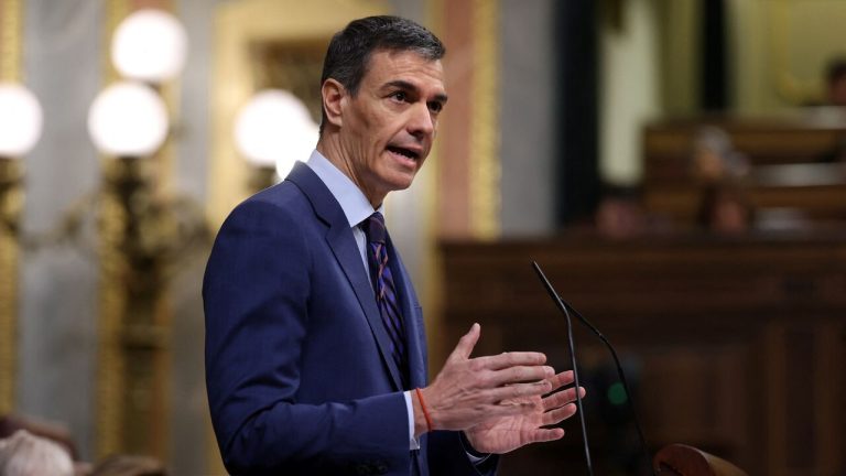 Spanish Prime Minister Pedro Sánchez speaking at a podium during a parliamentary session.
