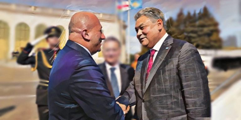 Two political leaders in suits shaking hands during an official diplomatic meeting outdoors.