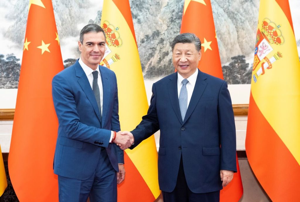 Pedro Sánchez and Xi Jinping shaking hands in front of Spanish and Chinese flags.