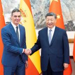 Pedro Sánchez and Xi Jinping shaking hands in front of Spanish and Chinese flags.