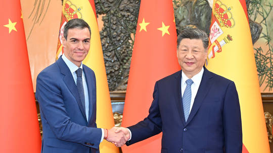 Spanish Prime Minister Pedro Sánchez shaking hands with Chinese President Xi Jinping in front of national flags.