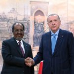 Recep Tayyip Erdoğan shaking hands with Hassan Sheikh Mohamud in front of a historical mural.