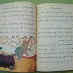 An open Persian children's storybook featuring an illustration of a group of birds attacking an elephant.