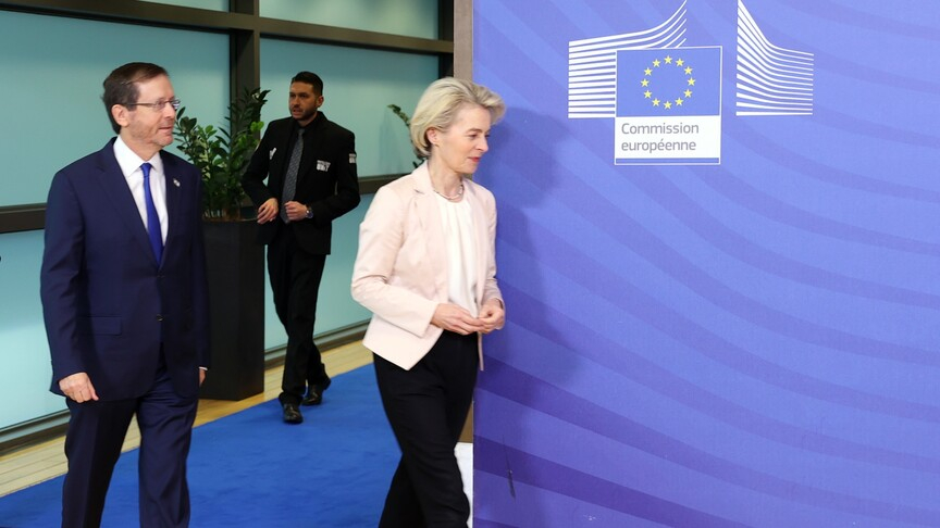 Ursula von der Leyen and Isaac Herzog walking together at the European Commission building in Brussels.