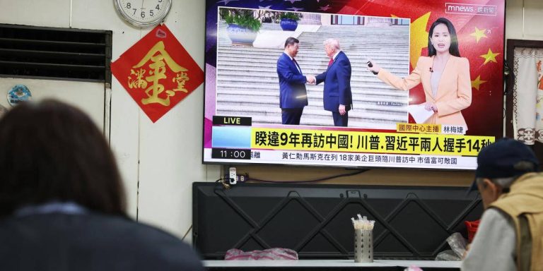 TV news broadcast showing Donald Trump and Xi Jinping shaking hands.