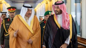 Saudi Crown Prince Mohammed bin Salman engaging in a conversation with a regional leader and military officials.
