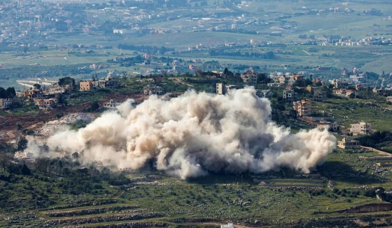 Large plume of smoke rising from an explosion in a hilly, residential area of Southern Lebanon.