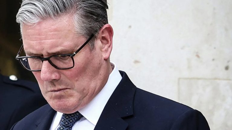 Close-up portrait of Keir Starmer looking downward with a serious expression.