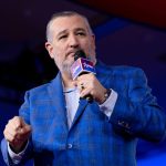 Ted Cruz speaking into a microphone at a CPAC event.