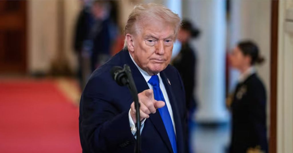 Donald Trump pointing a finger forward while standing at a podium.
