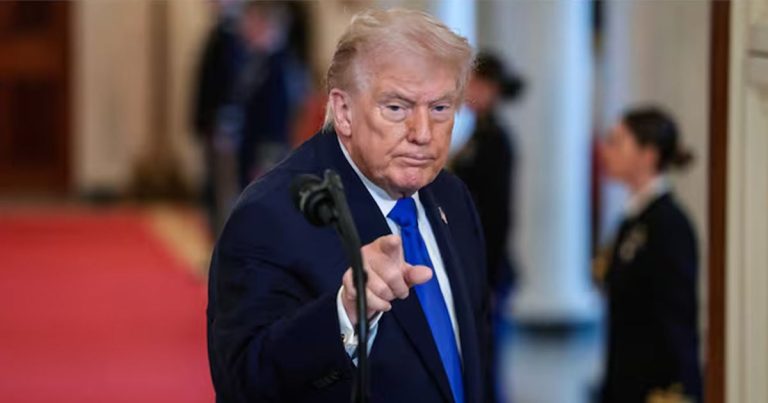 Donald Trump pointing a finger forward while standing at a podium.
