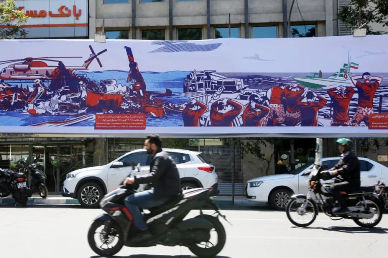 A large street billboard in Iran depicting military failures and naval captures.