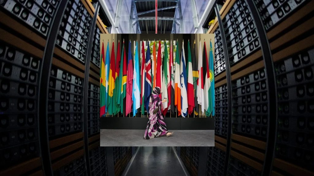 A person walking in front of a row of international flags set against a backdrop of server racks.