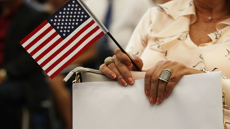 A person holding a small American flag in a public gathering.