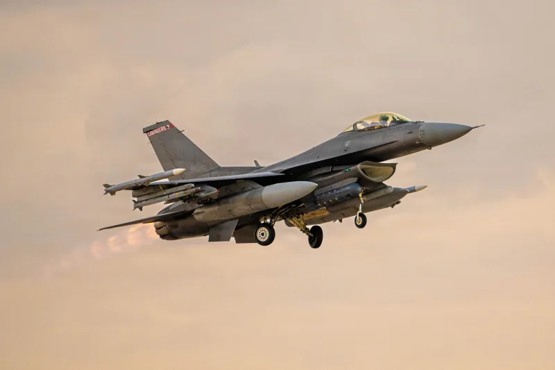 A U.S. F-16 fighter jet in flight, representing military power and global base presence.