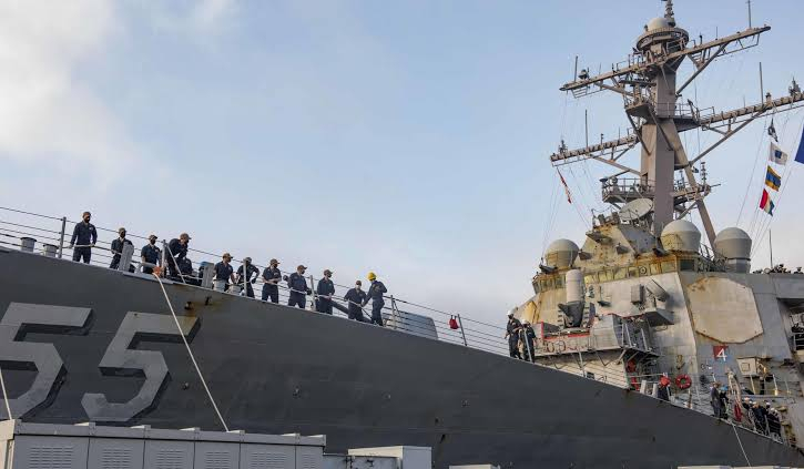 U.S. Navy sailors stand at attention on the deck of a naval vessel.