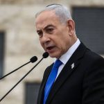 Benjamin Netanyahu speaking at a podium with a microphone.