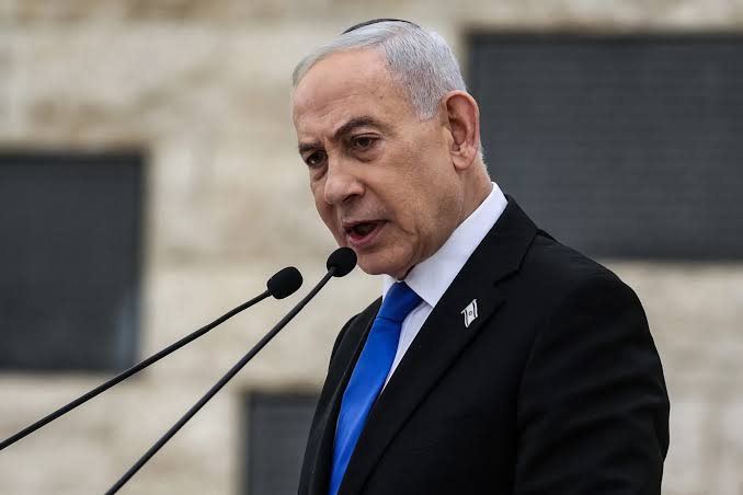 Benjamin Netanyahu speaking at a podium with a microphone.
