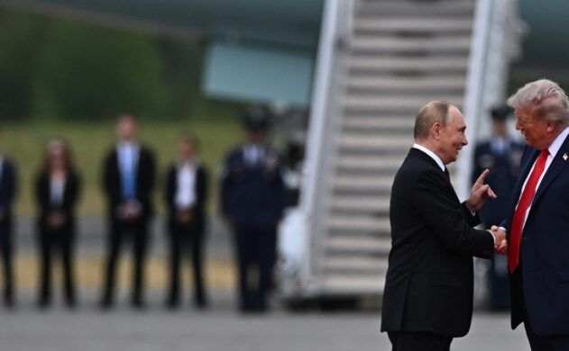 Vladimir Putin and Donald Trump shaking hands on an airfield.