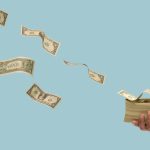 A hand holds a thick stack of U.S. dollar bills while other individual bills fly through the air against a light blue background.