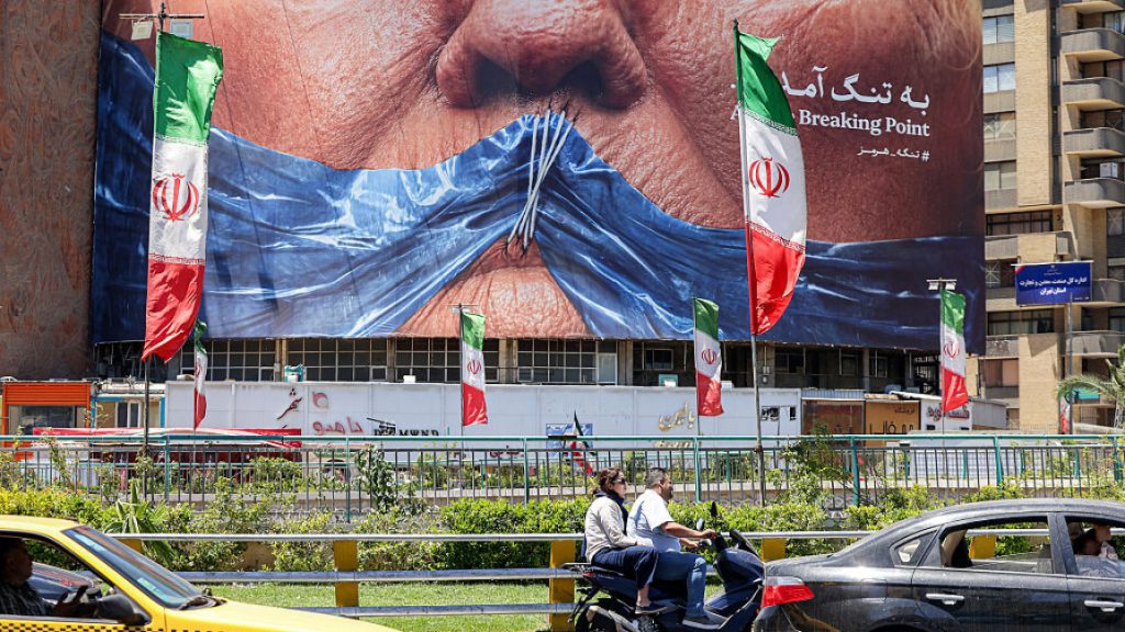 A large urban billboard in Iran displaying political imagery and flags with the Persian text "Breaking Point" at the Strait of Hormuz.