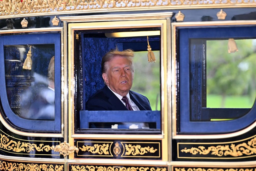 Donald Trump sitting inside a traditional golden-trimmed state carriage.