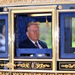 Donald Trump sitting inside a traditional golden-trimmed state carriage.