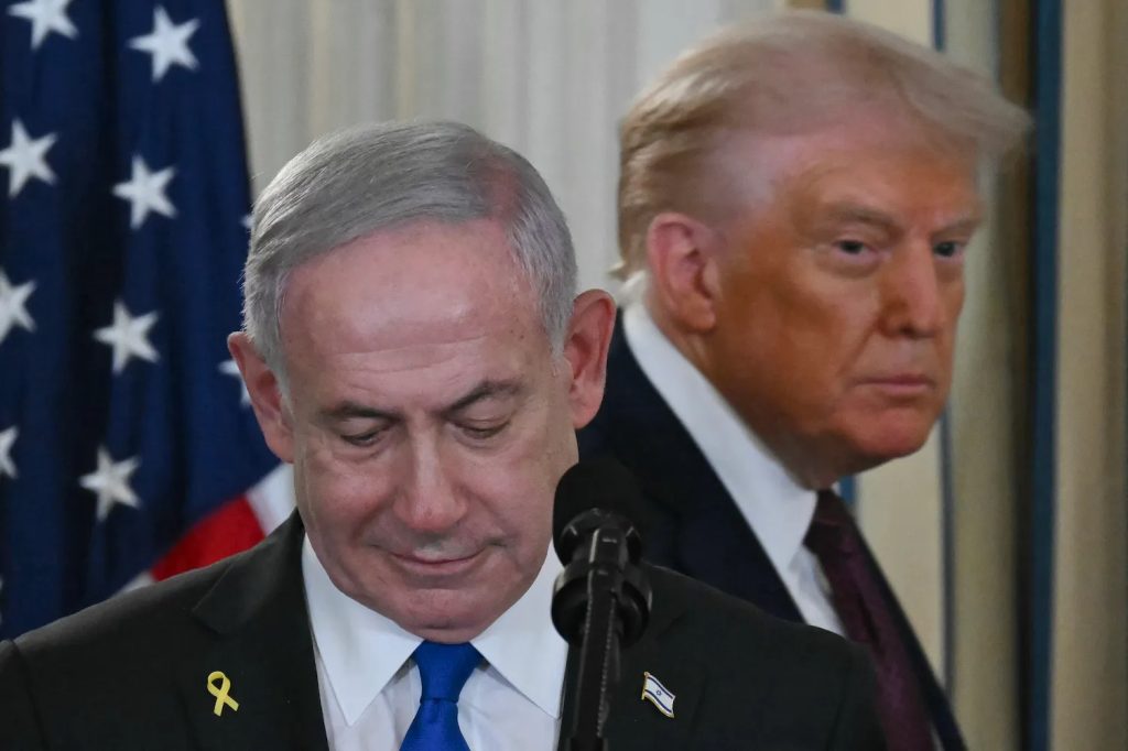 Benjamin Netanyahu speaking at a podium with Donald Trump standing in the background.
