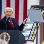 Donald Trump speaking at a podium while displaying a chart titled "Reciprocal Tariffs."