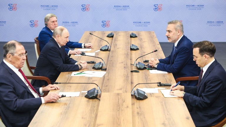 A high-level diplomatic meeting between Russian and Turkish officials around a conference table.